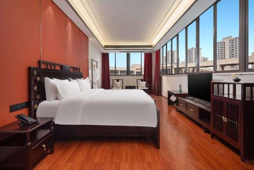 a bedroom with a large white bed and large windows at Days Inn by Wyndham Chongqing Tongliang in T'ung-liang-hsien