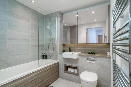 een badkamer met een douche, een toilet en een wastafel bij Madika Homes - Cosy 2 Bed 2 Bath in Colindale London in Colindale