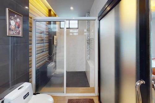 La salle de bains est pourvue de toilettes et d'une douche en verre. dans l'établissement Nutchana Hill Boutique Hotel, à Hat Yai