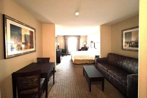 a hotel room with a couch and a bed at Ramada by Wyndham Prince Albert in Prince Albert