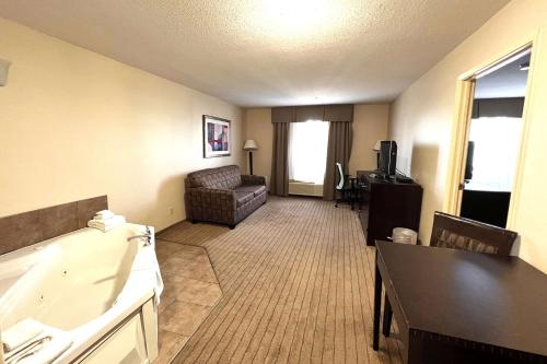 ein Wohnzimmer mit einem Zimmer mit einem Sofa und einem Tisch in der Unterkunft Ramada by Wyndham Prince Albert in Prince Albert