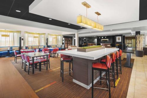 a restaurant with a bar with red chairs at Super 8 by Wyndham Dallas Love Field Airport in Dallas