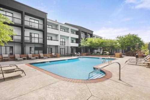 a swimming pool in front of a building at Super 8 by Wyndham Dallas Love Field Airport in Dallas