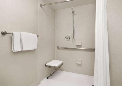 a bathroom with a shower with a toilet and a shower curtain at Super 8 by Wyndham Dallas Love Field Airport in Dallas