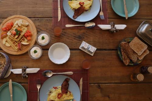a wooden table with plates of food on it at Gemstone Farm in Plettenberg Bay