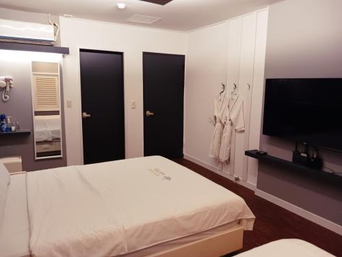 a bedroom with a bed and a flat screen tv at Victoria Hotel in Mokpo