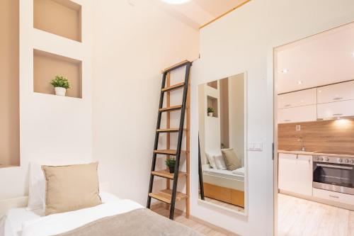 une petite chambre avec une échelle à côté d'une cuisine dans l'établissement Central and Cute with 3 rooms and AC, à Budapest