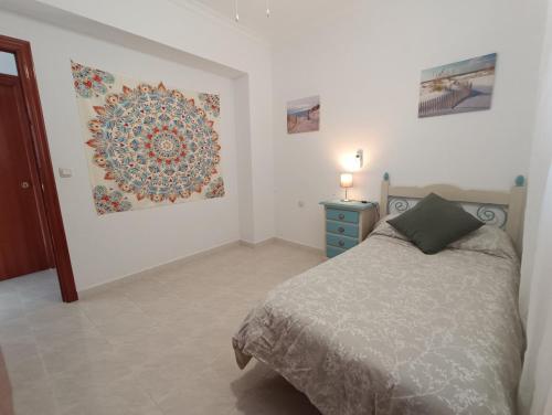 ein Schlafzimmer mit einem Bett und einem Wandgemälde in der Unterkunft APARTMENT WITH SINGLE ROOMS in Algodonales