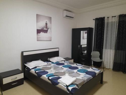 - une chambre dotée d'un lit avec des draps bleus et blancs dans l'établissement CHEZ CODOU MEDINA, à Dakar