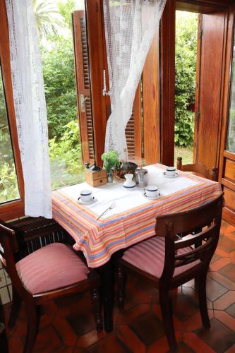 einen Tisch mit 2 Stühlen in einem Zimmer mit Fenster in der Unterkunft Chalet céntrico/costero en Gijón in Gijón