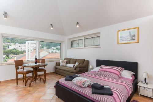 1 dormitorio con cama, mesa y sofá en Apartments Dia, en Dubrovnik