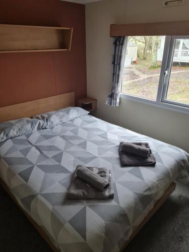 a bedroom with a checkered bed with two bags on it at 28 Oaklands in Porchfield