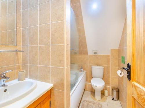 a bathroom with a sink and a toilet and a bath tub at Oak Cottage in Ware