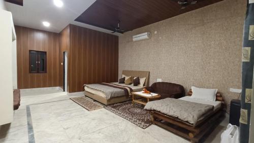 a living room with two beds and a couch at Sal Tree Resort by Vihasta, Kanha in Lagma