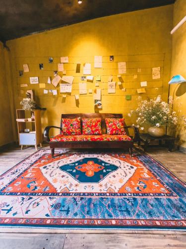 a living room with a couch on a rug at Maison de Hill Home in Dồng Văn