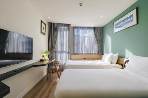 a hotel room with two beds and a flat screen tv at MO Hotel Bangkok in Bangkok