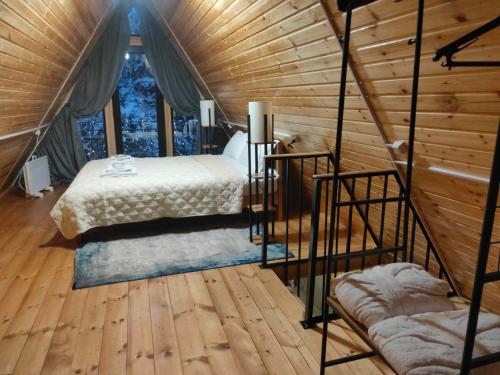 1 dormitorio con 1 cama en una cabaña de madera en M&L, en Mestia