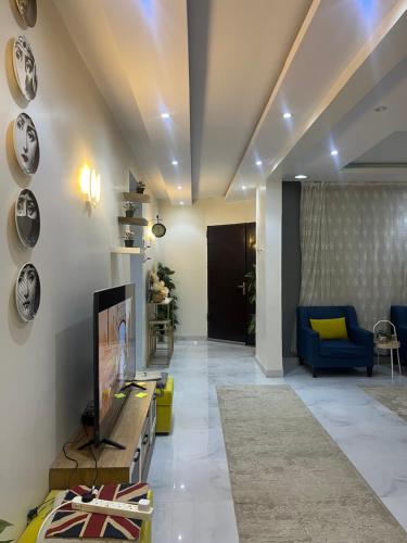 - un salon avec une télévision et un canapé bleu dans l'établissement فيلا, à Hafr Al Baten