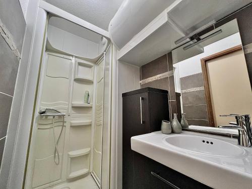 a bathroom with a sink and a shower and a mirror at Studio La Belle Vue in Xonrupt-Longemer