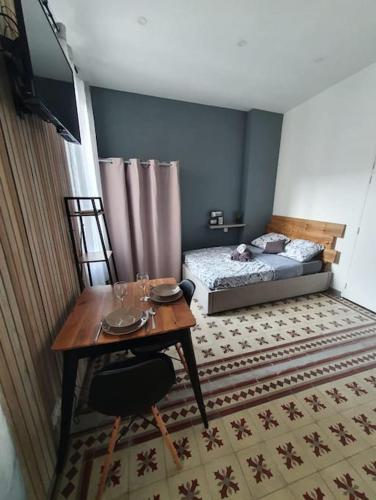 Cette petite chambre comprend une table et un lit. dans l'établissement Studio confort pour 2 Perpignan Bir Hakeim, à Perpignan
