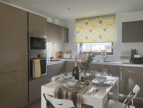 a kitchen with a table with a bottle of wine at Wembley residency in Brent