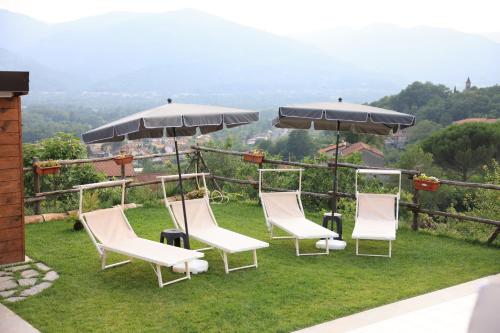 a group of chairs and umbrellas on the grass at Il Paradiso di Pietra in Filetto
