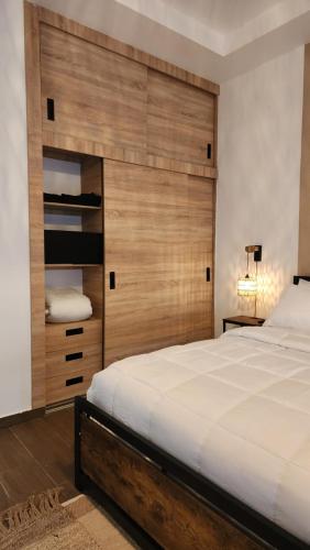 a bedroom with a large bed and a wooden wall at Modern Boho Apt in Punta Cana in Punta Cana