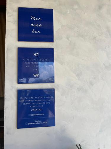 tres signos azules y blancos en una pared en Casa com Piscina, Rede Suspensa e Praia Privativa, en Mangaratiba
