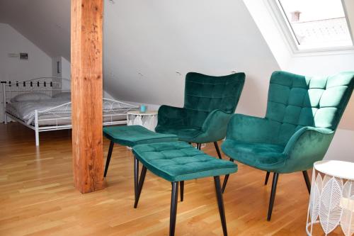 2 sillas verdes y un espejo en una habitación en Apartment in the center of Kranj en Kranj