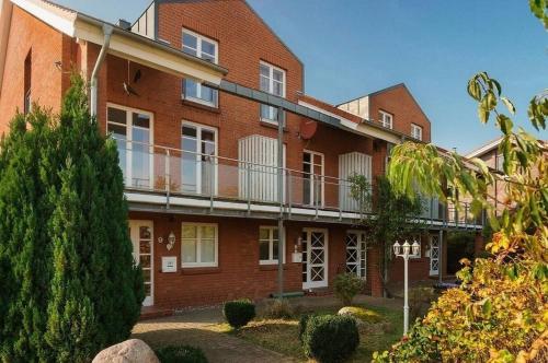 a red brick building with a balcony on it at Strandhaus Fiete - Haus Poelblick - ABC247 in Hohen Wieschendorf