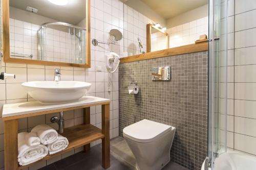 a bathroom with a sink and a toilet and a shower at Hotel Naturum in Milicz