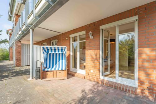 einem blauen und weißen Stuhl vor einem Gebäude in der Unterkunft Strandhaus Fiete - Haus Poelblick - ABC247 in Hohen Wieschendorf