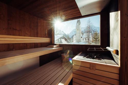 a sauna with a window and a stove at Hotel Tradizio in Mittelberg