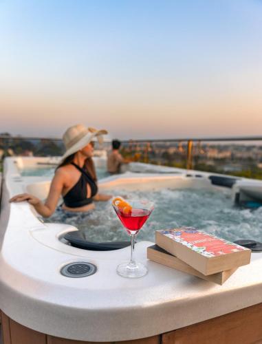 a woman sitting in a hot tub with a drink at LP Vilas in Dehradun