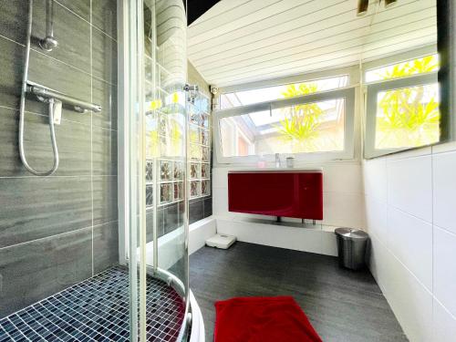 W łazience znajduje się prysznic i czerwona umywalka. w obiekcie Bordeaux Terrace w mieście Bordeaux