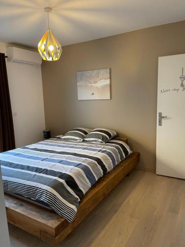 een slaapkamer met een bed met een blauw en wit dekbed bij Un cocon au cœur du village in Saintes-Maries-de-la-Mer