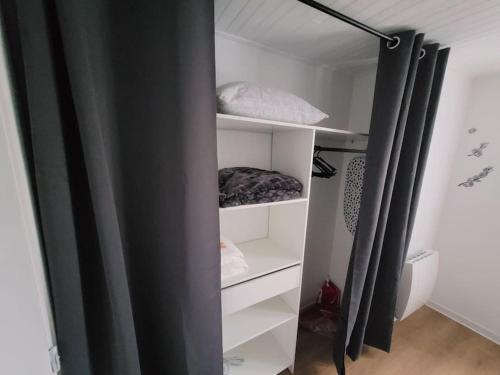 MernelにあるLa Parentaiseの白い棚と黒いカーテン付きのクローゼット