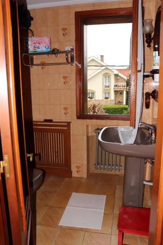 a bathroom with a sink and a window at Chalet céntrico/costero en Gijón in Gijón