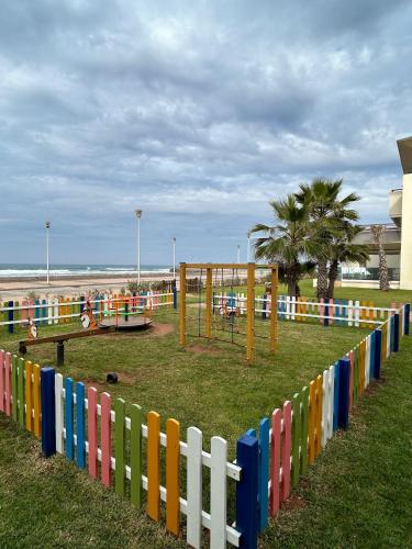 a colorful fence in front of the beach at Havre de paix au BahiaGolf Beach, Résidence Front Mer in Bouznika