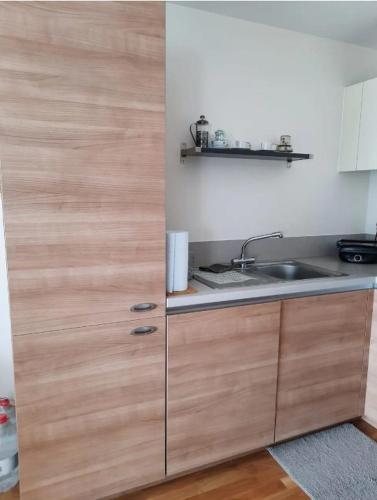 a kitchen with wooden cabinets and a sink at Cosy private room in Streatham Hill