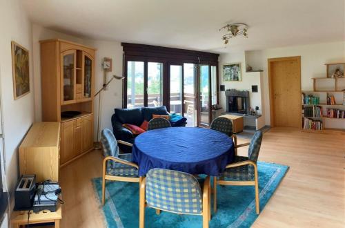 uma sala de estar com uma mesa azul e cadeiras em Casa Surselva Wohnung Nr. 5 Marti em Savognin