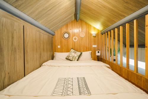 a large bed in a room with wooden walls at Shanghai River View Villa in Shanghai