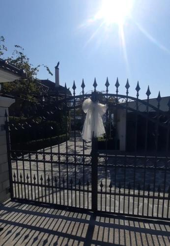 Una mujer con un vestido blanco parada en una valla en Guest House Xhelili, 