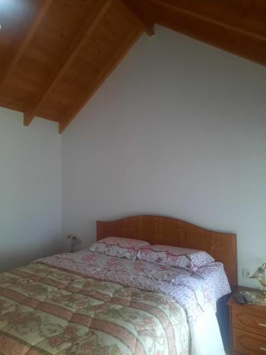 1 dormitorio con cama y techo de madera en Guest House Xhelili, 