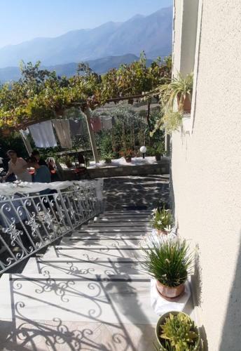 balcón con mesa, sillas y plantas en Guest House Xhelili, 