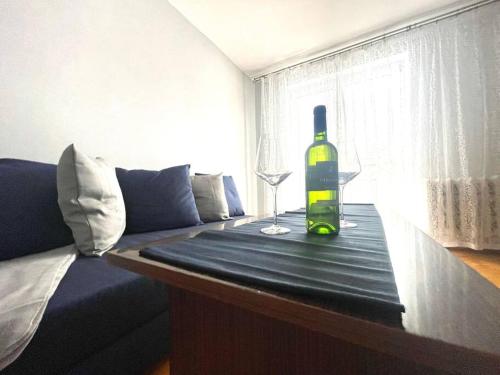 MIESZKANIE W IDEALNEJ LOKALIZACJI في سوسنوفييتس: زجاجة من النبيذ وكأس على الطاولة