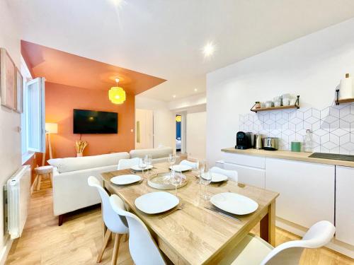 Il dispose d'une cuisine et d'un salon avec une table et des chaises en bois. dans l'établissement Le Bohème 21 - Proche Gare - Fibre - Lumineux, à Saint-Nazaire