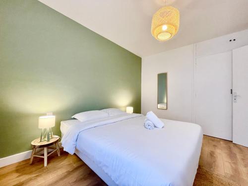 une chambre avec un lit blanc et un mur vert dans l'établissement Le Bohème 21 - Proche Gare - Fibre - Lumineux, à Saint-Nazaire