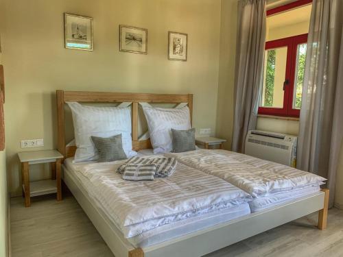 1 dormitorio con 1 cama grande con sábanas y almohadas blancas en Beck's Borveranda Palkonya, en Palkonya