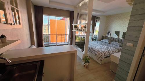 a small room with a bed and a kitchen at I chill Six Room in Ban Bang Saen (1)